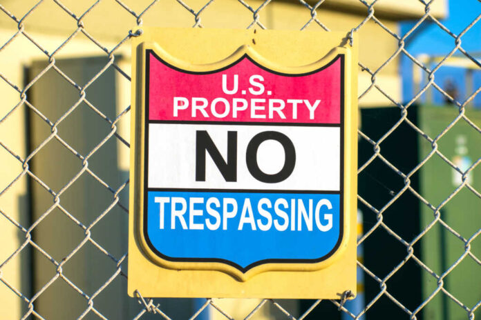 U.s.,Property,No,Trespassing,Sign,Attached,To,A,Chain,Link
