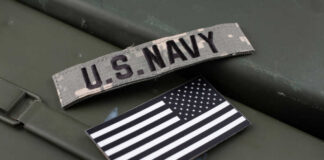 U.S. Navy patch and American flag on a green surface