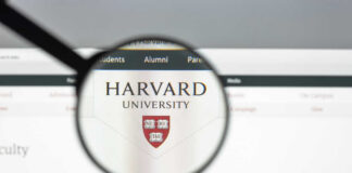 Magnifying glass focusing on the Harvard University logo on a website