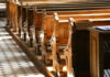 Interior of a church featuring wooden pews and natural light streaming in