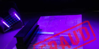 A passport under UV light with a stamp indicating fraud