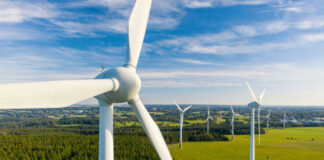 Aerial view of wind turbines in a green landscape under a blue sky