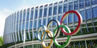 Colorful Olympic rings displayed in front of a modern building
