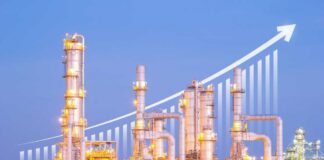 Illuminated industrial oil refinery with a growth graph overlay