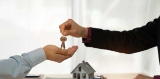 A person handing over house keys during a real estate transaction