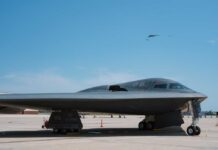 A B-2 stealth bomber on an airfield under a clear blue sky