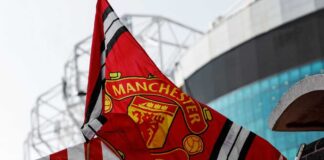 Manchester United flag waving in front of a stadium