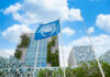 Modern building with UN flag in front under a blue sky with clouds