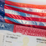 Close-up of a US visa with an American flag in the background