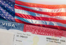 Close-up of a US visa with an American flag in the background