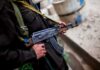 Soldier holding an AK-47 rifle in a conflict area