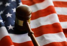 A wooden gavel resting on an American flag