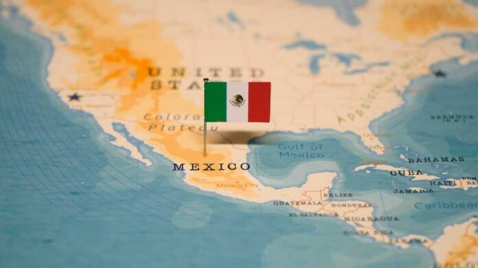 shutterstock_2406904423.jpg Map of North America with a flag of Mexico pinned on it