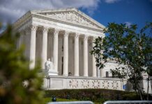 The Supreme Court building with columns and a statue in front