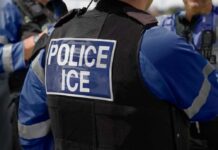 ICE Raid Chaos Erupts At DMV Close-up of a police officer's vest with 'POLICE ICE' label