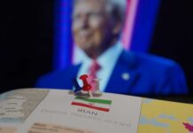 Map of Iran with push pins and a blurred figure in the background