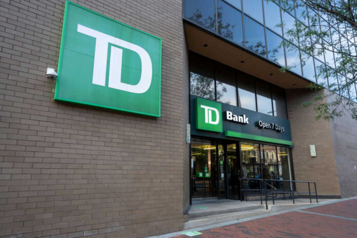 shutterstock2232317311jpg Exterior view of TD Bank with a sign indicating it is open 7 days