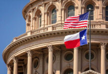 American and Texas flags flying in front of a state capitol building