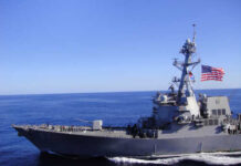 Iran Escalation? US Claims Self-Defense A naval destroyer sailing in the ocean with an American flag