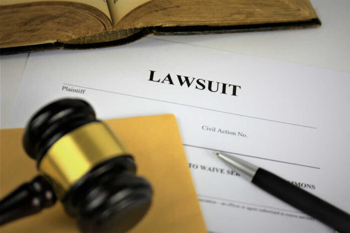 An,Image,Of,A,Lawsuit A gavel resting on a legal document titled 'LAWSUIT' with a pen and an open book in the background