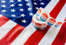 Greene EXPOSES Alleged Trump Election Delay Plot Voting stickers on an American flag background
