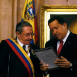 Two officials examine a framed document during a ceremony