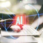 A hand interacting with a laptop displaying an AI symbol