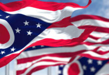 Waving Ohio state flags against a blue sky