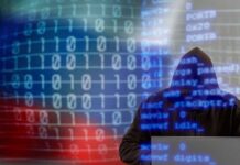 Shocking Cyber Breach! U.S. Fuel Supply in Danger A hooded figure working on a laptop with binary code in the background