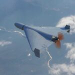A drone flying high above the clouds with a visible propeller
