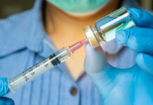 Ebola Vaccine Breakthrough? Oxford Moves Fast! Healthcare professional preparing a syringe from a vial