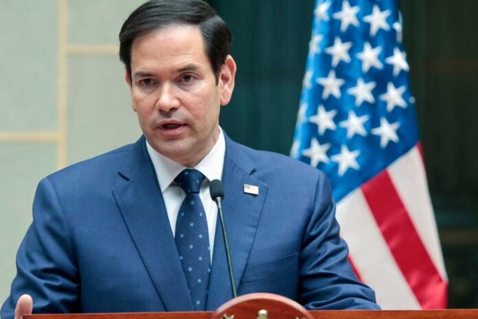 Marco Rubio speaking at a podium with an American flag in the background