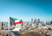 Iranian Guards Caught In Kuwait: Shocking Escalation Kuwait flag waving over a city skyline with modern buildings