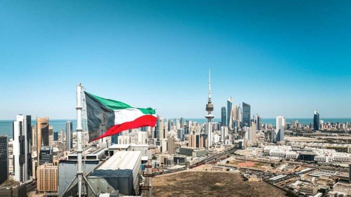 Kuwait flag waving over a city skyline with modern buildings