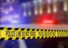 Yellow police tape reading 'DO NOT CROSS' at a crime scene