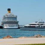 A large cruise ship and a ferry docked in a harbor