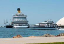 A large cruise ship and a ferry docked in a harbor