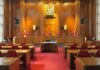 CEO Murder Trial: Shocking Courthouse Scenes Interior view of a courtroom with wooden paneling and red seating