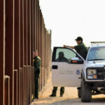 U.S. Customs and Border Protection officers near a border fence