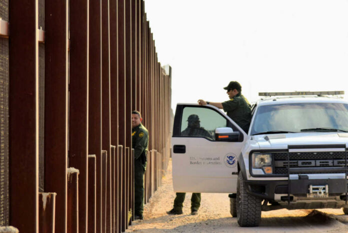 shutterstock1545833798jpg U.S. Customs and Border Protection officers near a border fence