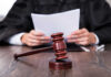 Ballroom Brawl Exposes Scary Legal Loophole A judge holding documents with a gavel in the foreground