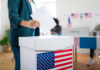 Ballot Crackdown Looms — States Move Fast A person casting a vote into a ballot box at a polling station