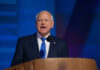 Oversight Bomb Drops On Minnesota A man in a suit speaking at a podium with a microphone