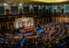 DOJ’s $1.8B Bombshell Backfires A large gathering of officials in a congressional chamber during a legislative session