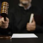 A judge holding a gavel in a courtroom setting