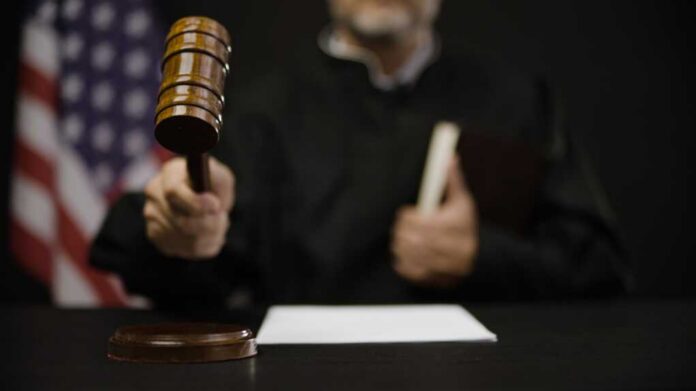 A judge holding a gavel in a courtroom setting