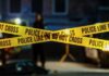 Phone Grab Turns Fatal—City On Edge Police tape marking a crime scene with blurred figures in the background