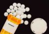 Prescription bottle of fentanyl with white pills scattered around