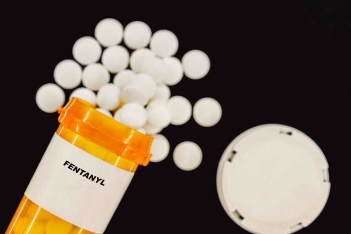 Prescription bottle of fentanyl with white pills scattered around
