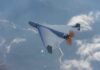 Contractor Grip Tightens On Combat AI A drone flying high above the clouds with a visible propeller